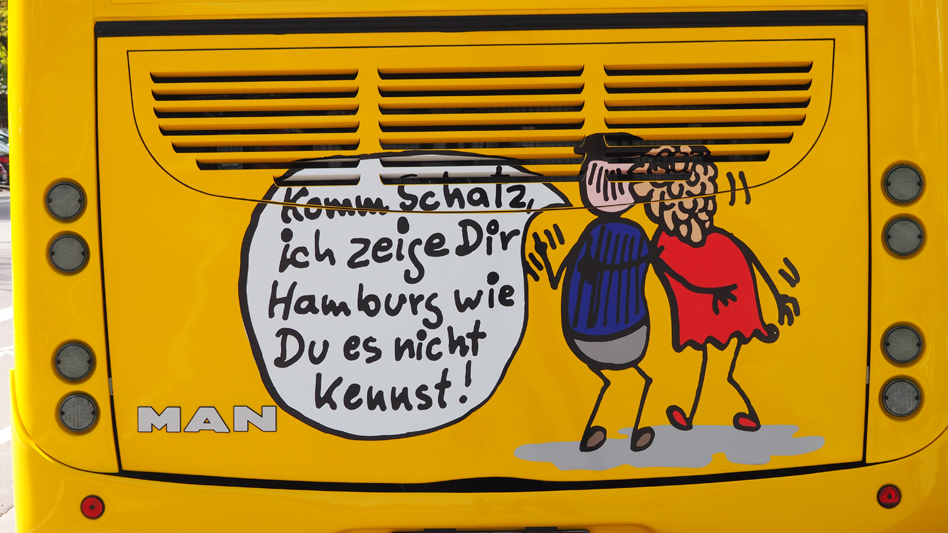 Ein gezeichnetes Bild auf einem Bus. Der Mann sagt der Frau. Komm Schatz, ich zeige Dir Hamburg wie du es nicht kennst.